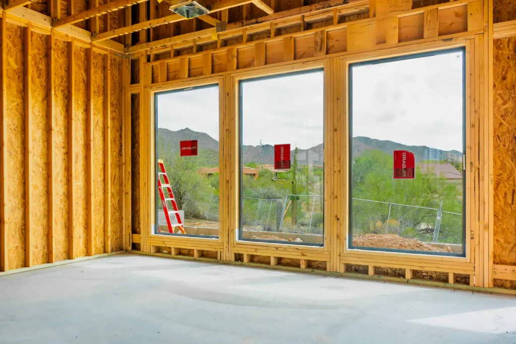 Interior construction of a custom new home in Mesa, Arizona featuring wood framing, large energy-efficient windows, and structural preparation by Cowboy's General Construction LLC.