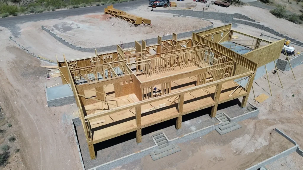 Aerial view of the structural framing stage for a new home construction project in Mesa, AZ by Cowboy's General Construction.