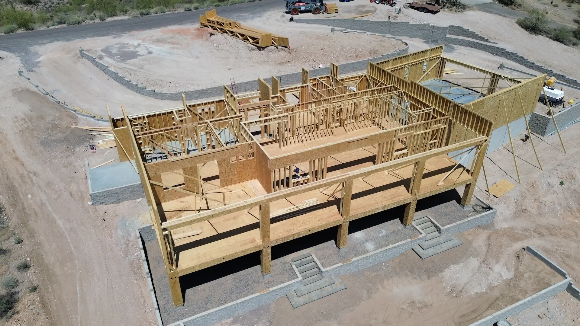 Aerial view of the structural framing stage for a new home construction project in Mesa, AZ by Cowboy's General Construction.